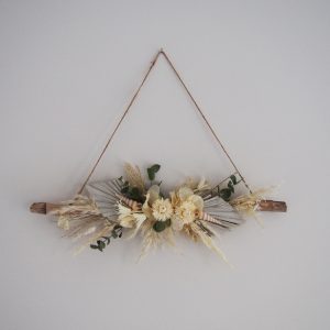 suspension branche de bois flotté décorée avec des fleurs séchées blanches et coquillages