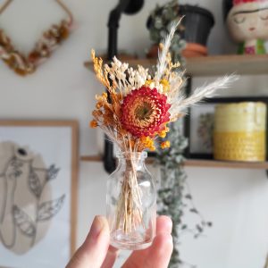 Mini bouquet de fleurs séchées oranges dans une fiole transparente